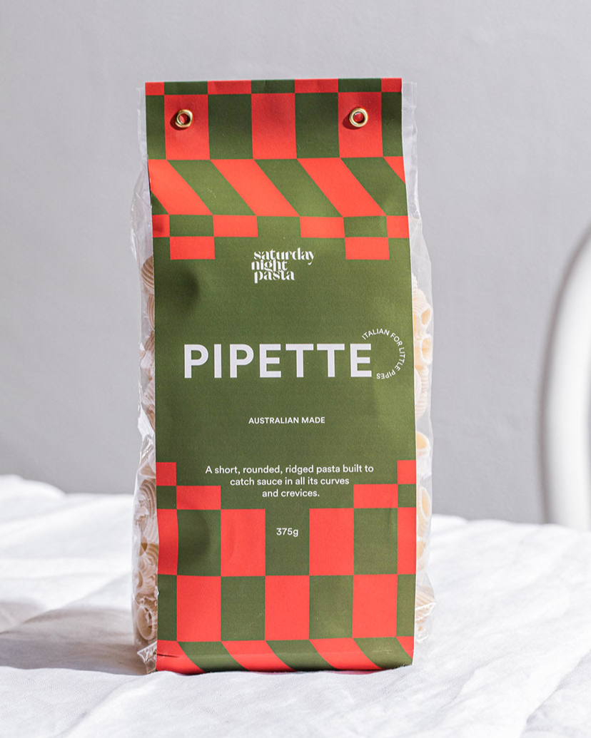 Packaged Pipette pasta with green and red checkered design on a white surface